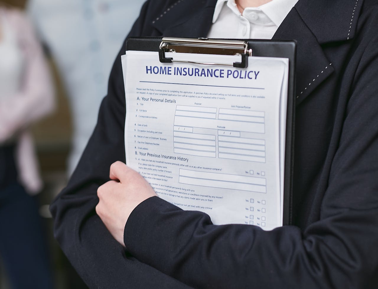 services-hero Close-up of a person holding a home insurance policy on a clipboard, captured indoors.
